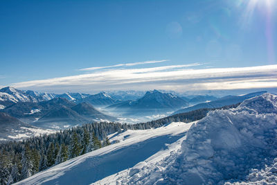 Scenic view of snowcapped mountains against blue sky