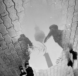 Low section of people standing on puddle