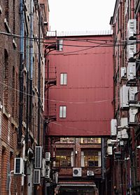 Red building in city against sky