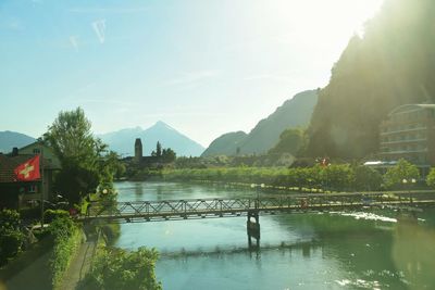 Scenic view of river by mountains against sky