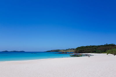 Scenic view of beach against clear blue sky