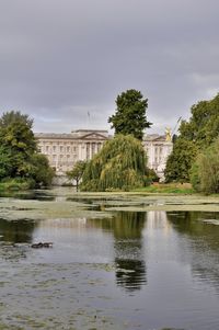 Scenic view of lake by buildings against sky