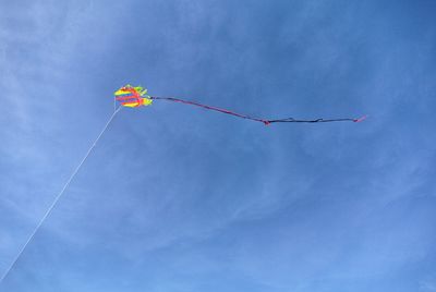 Low angle view of kites against blue sky