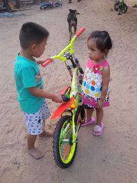 High angle view of siblings standing on sand