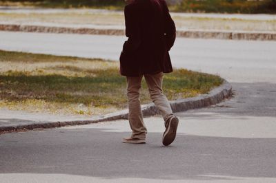 Low section of man walking on road
