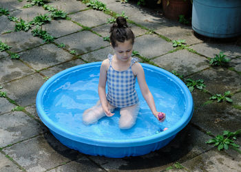 Young girl playing in the pool in the backyard