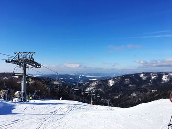 Snow covered mountain against blue sky