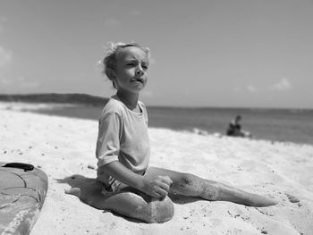 Boy sitting at beach against