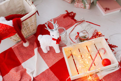 Christmas decor, white deer toy, lollipop cane, lights on a red white plaid