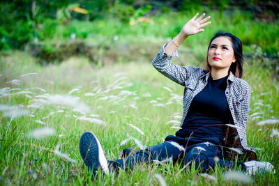 Young woman sitting on field