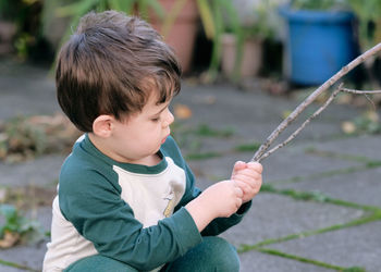 Boy playing with a stick in the garden