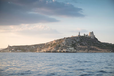 Lighthouse by sea against sky