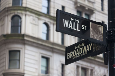 Low angle view of information sign against building in city