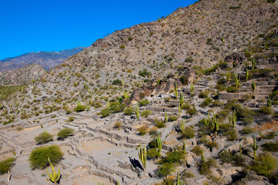 Scenic view of land and mountains against clear sky