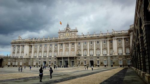 People outside royal palace of madrid in city