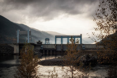 River by buildings against sky