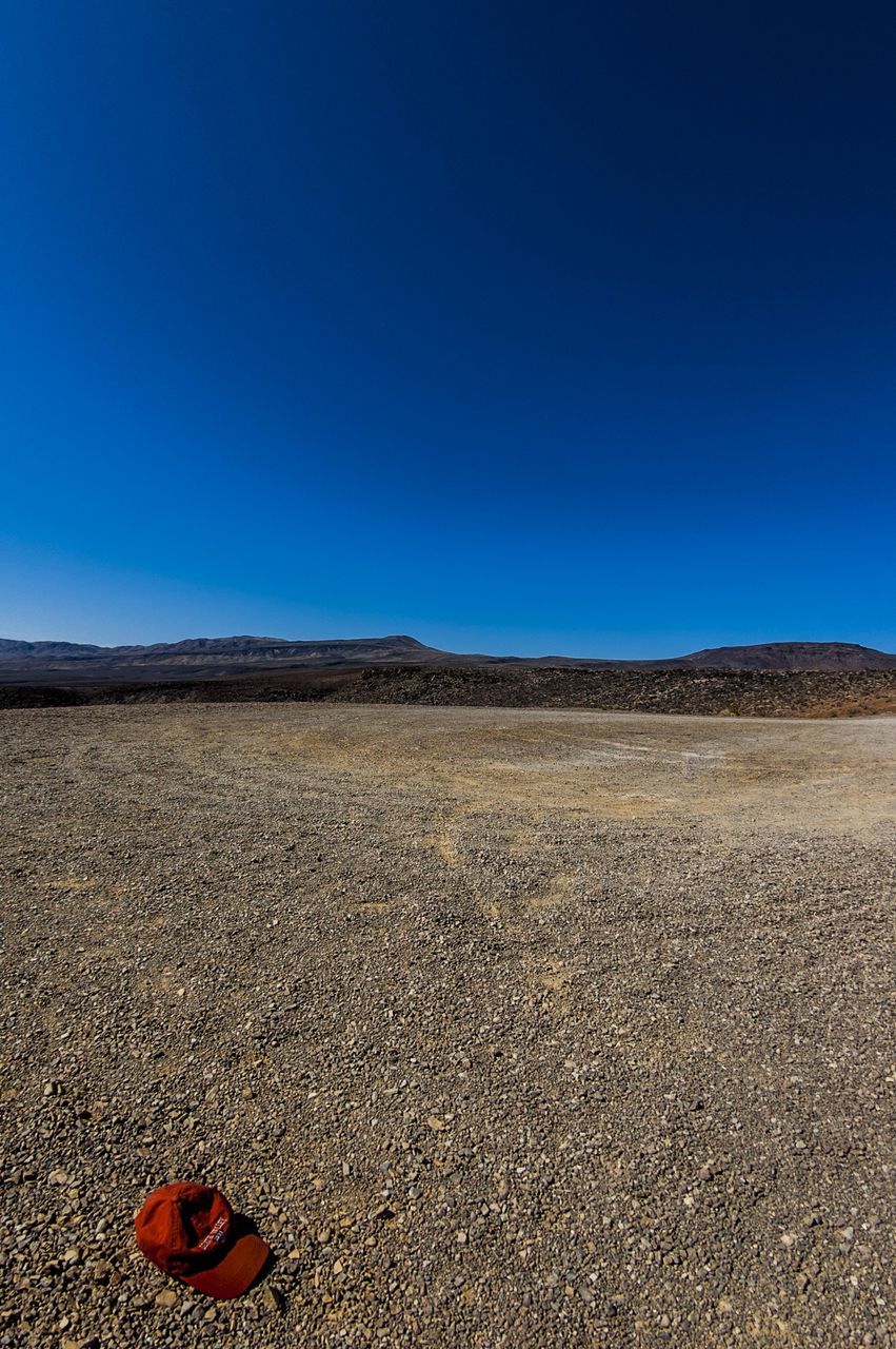 clear sky, blue, copy space, sand, desert, tranquil scene, tranquility, landscape, arid climate, scenics, nature, beauty in nature, beach, sunlight, outdoors, day, horizon over land, no people, barren, remote