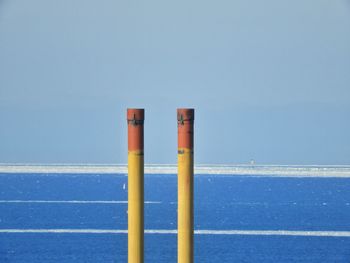 Close-up of metallic poles against clear blue sky