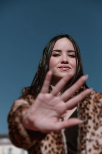 Portrait of a smiling young woman against gray background