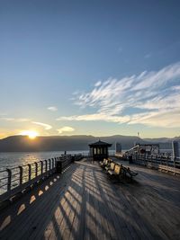 Pier over sea against sky during sunset