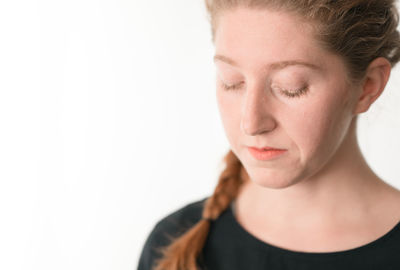 Close-up of young woman against white background