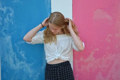 Teenage girl standing against colorful wall