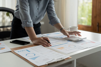 Midsection of business colleagues working on table