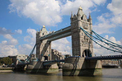 Low angle view of tower bridge over river against sky