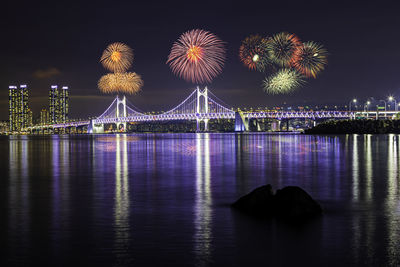 Illuminated ferris wheel in city at night