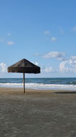 Lifeguard hut on beach against sky