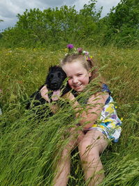 Girl and black dog in meadow 