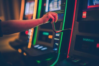 Cropped hand of boy playing games on slot machine