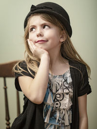 Portrait of beautiful young woman against wall
