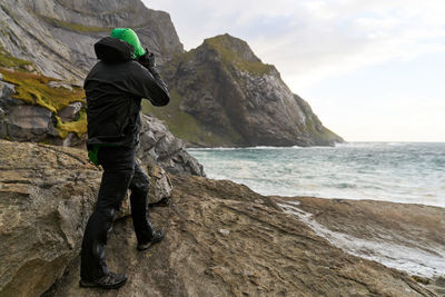 Full length of man looking at sea while standing on rock