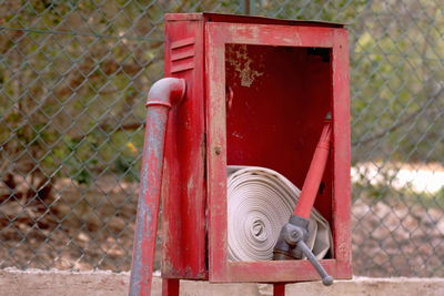 Close-up of fire hydrant against red fence