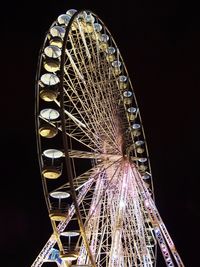 Low angle view of illuminated ferris wheel against sky at night