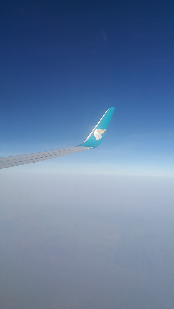 blue, sky, flying, nature, air vehicle, airplane, mid-air, environment, no people, travel, horizon, aircraft wing, copy space, wing, transportation, vehicle, day, tranquility, aerial view, beauty in nature, windsports, scenics - nature, clear sky, outdoors, tranquil scene, journey, mode of transportation, water, air travel