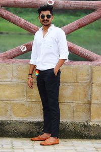 Portrait of young man standing against wall