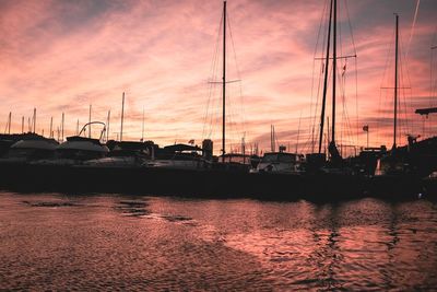 Silhouette harbor against sky during sunset