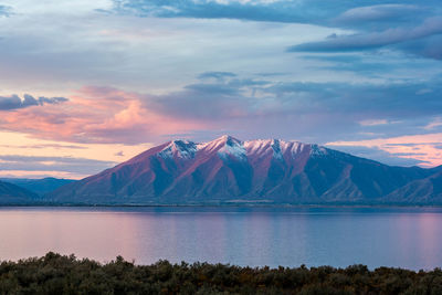 Scenic view of lake and mountains against sky during sunset