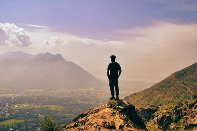 Rear view of man looking at mountain against sky