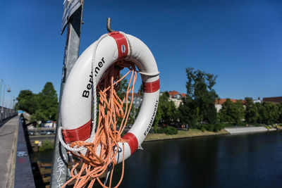 Close-up of buoy attached to pole by lake