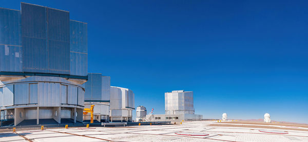 Buildings in city against clear blue sky