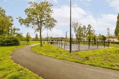 Road amidst trees against sky