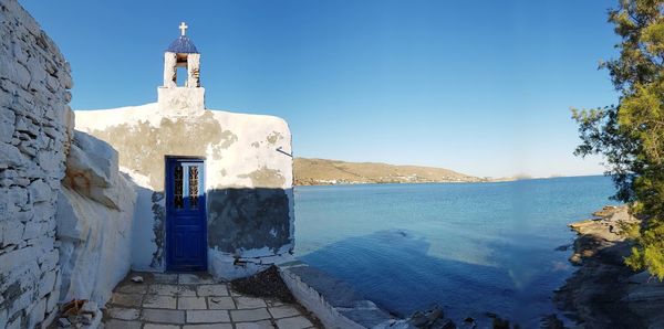 Exterior of building by sea against blue sky