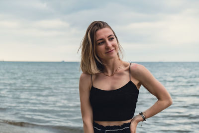 Portrait of young woman standing at beach