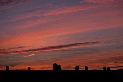 Silhouette built structures against scenic sky