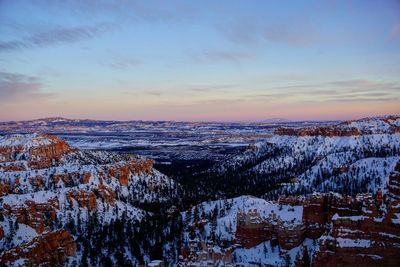 Aerial view of snow covered landscape during sunset