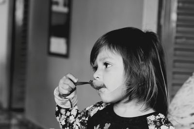 Close-up of girl having food at home