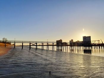 Pier over sea against sky during sunset